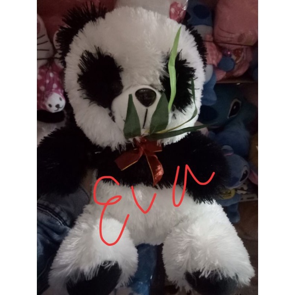 Boneka panda makan rumput