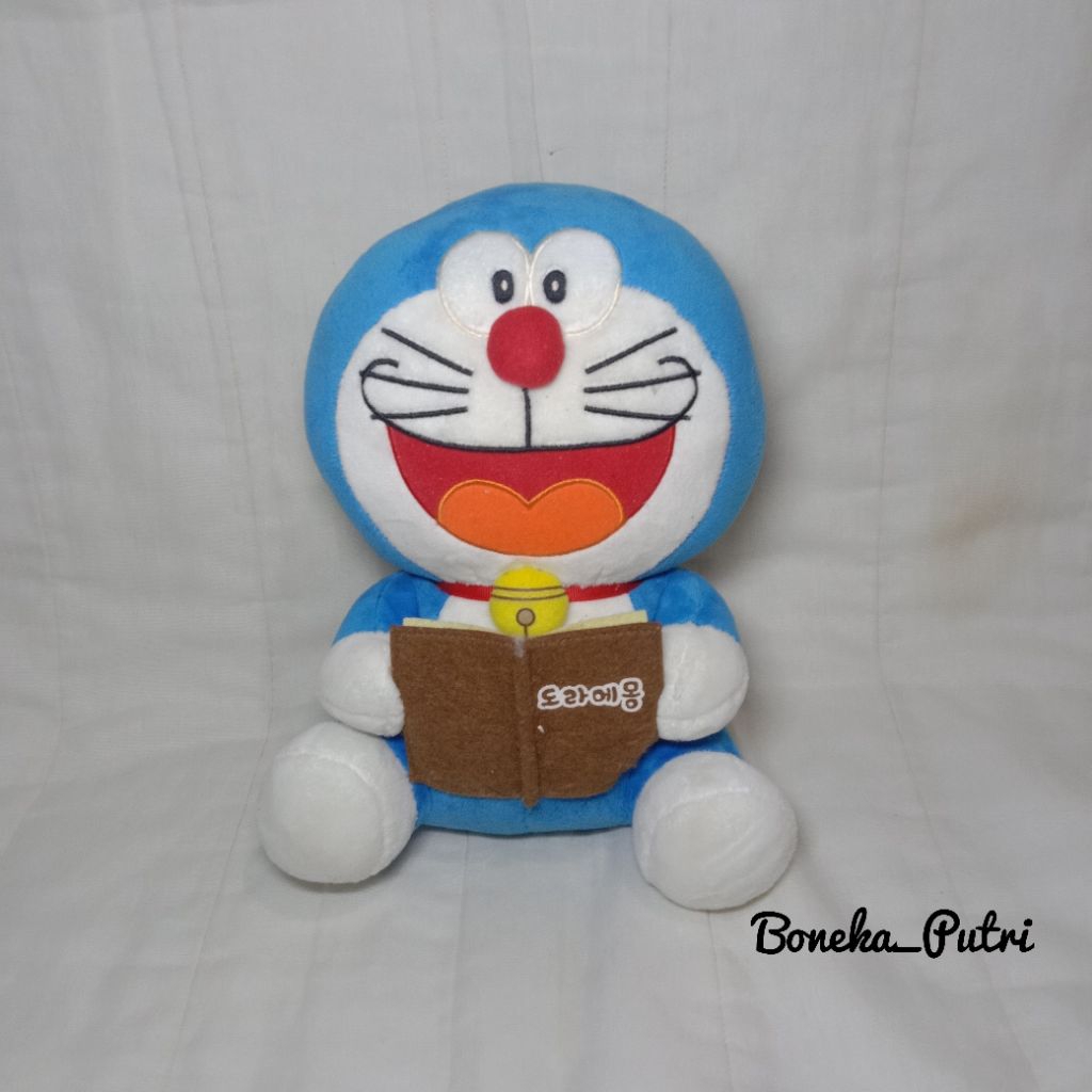 Boneka Doraemon Bawa Buku